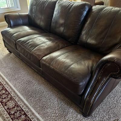Leather sofa with nail head trim.  One of two.