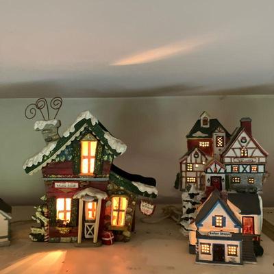 (17pc) Christmas Village | Ceramic lighted Village has assorted houses and shops including The Chatham Inn, Christmas Village Inn, Claus...