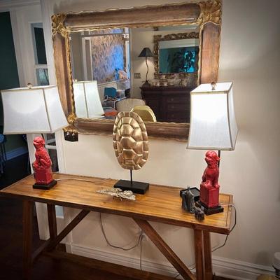 Wood console table, wall mirror, and two foo dog lamps