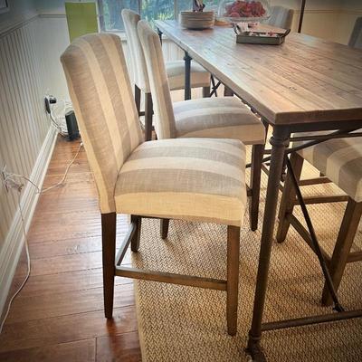 98" long bar-height dining table. Six chairs shown, but can seat 8-10. Chairs are bar-height, with gray and white striped upholstery.