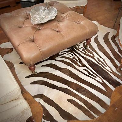 Zebra-skin rug and oversized leather ottoman on wheels 
