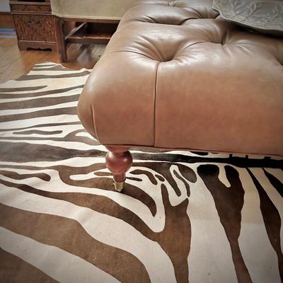 Zebra-skin rug and oversized leather ottoman on wheels