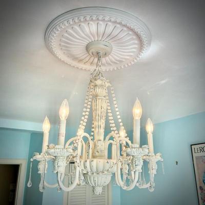 White chandelier located in bedroom