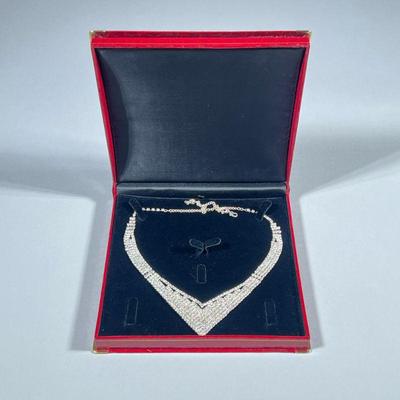 DIAMOND SIMULANT NECKLACE | Designed as a curved v-shape diamond simulant necklace, in a red alligatored presentation box. - w. 7 x l....