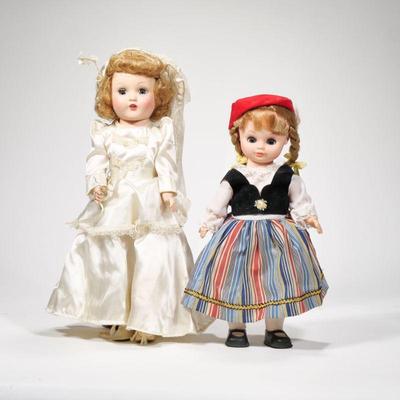 (2pc) PAIR PORCELAIN DOLLS | Includes; girl in wedding dress and girl in traditional European wear. Doll height: 15in - h. 5.5 x w. 9.5 x...
