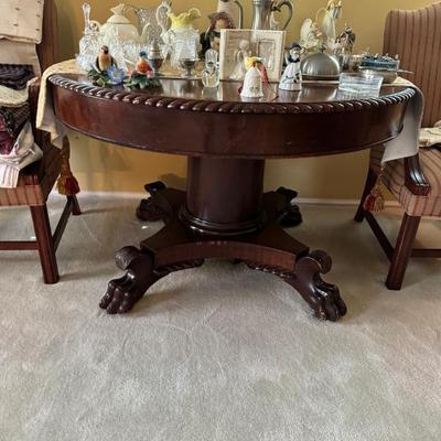 Antique Carved mahogany round footed pedestal dining table.