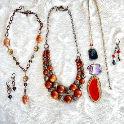Collection of bohemian-style jewelry in earthy tones and natural stone accents as well as wooden beads with intricate sterling silver...