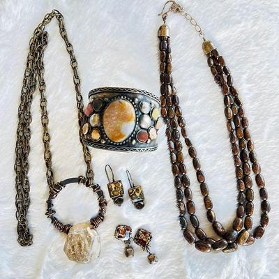 Bohemian-inspired jewelry featuring an Hand crafted necklace with a large quartz pendant, two pairs of coordinating earrings, an...