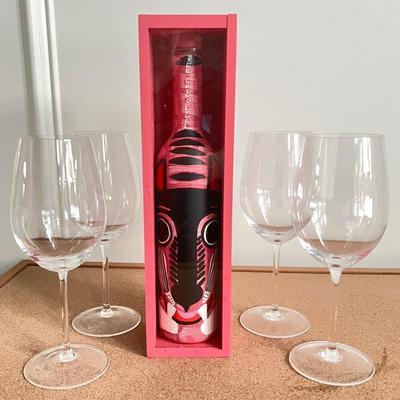 Empty wine bottle and four crystal wine glasses