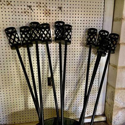 Lot 043-GAR: Tiki Torch Assortment 

Features: 
•	10 metal Tiki Torch poles
•	Tiki torch oil
•	Note that poles do not have canisters,...