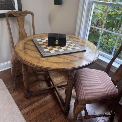 Round game table with two accompanying chairs