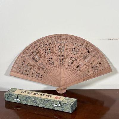 CHINESE WOOD FAN | Reticulated wood fan decorated with figures, in a silk box. - l. 9 in

