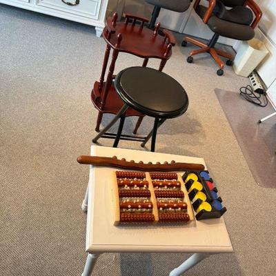 White Side Table, Foot Massager Roller,  Bead Massager Roller Guasha Wood Stick, Polker Chips. Black Padded Folding Stool, Plant Stand.