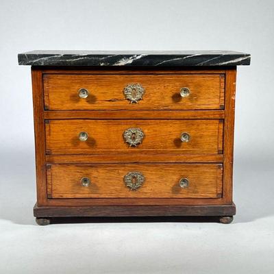 MINIATURE CHEST with MARBLE TOP | Chest with three inlaid drawers on bun feet, having brass pulls & escutcheons, with attached black...