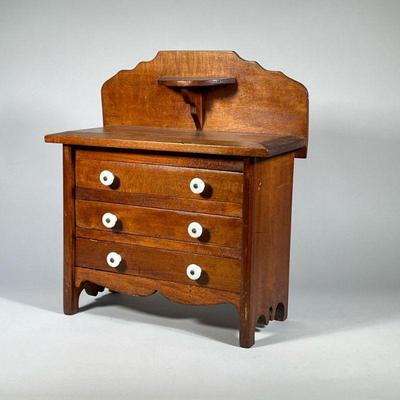 MINIATURE CHEST WITH BACKSPLASH | Miniature three drawer chest, each drawer with double porcelain pulls over a shaped apron, with candle...