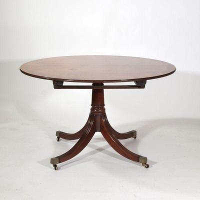 REGENCY STYLE PEDESTAL BREAKFAST TABLE | Round top table with inlaid wood border, over four reeded legs terminating in brass capped feet,...