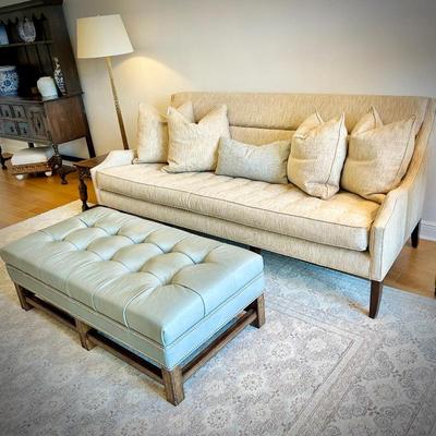 Off-white Century linen sofa, light blue leather ottoman, and light oriental rug
