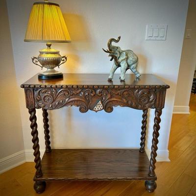 Antique European console table with barley twist legs. Fleur de Lis on the shield carved into the front. Also pictured - bronze elephant...