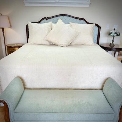 King bedframe with light Tiffany blue upholstered headboard, mattress, and linens, and light turquoise upholstered bench