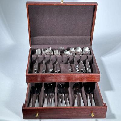 MCM “THE MAIN COURSE” STAINLESS STEEL FLATWARE SERVICE | Mid-century modern flatware set in fitted wood box. - h. 6 x w. 15 x d. 11 in...