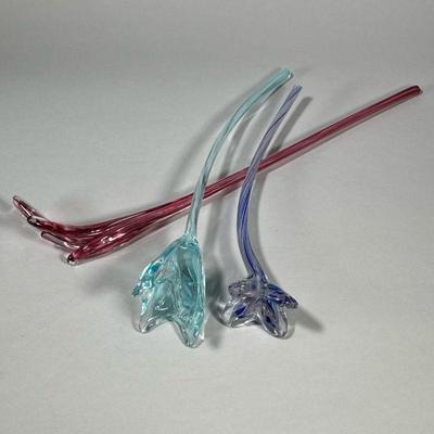 (3pc) BLOWN GLASS FLOWERS | Decorative glass flowers, including blue, pink/red, and purple. - l. 20 in (longest)

