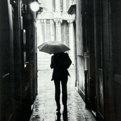 European Umbrella Photograph | Framed black and white photograph of a figure on a rainy promenade. - h. 21.5 x w. 18 in (frame)

