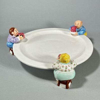 FUN LOTUS ART CERAMIC CAKE PLATTER | By Lotus, with three figures around the rim. - h. 5 x dia. 14 in

