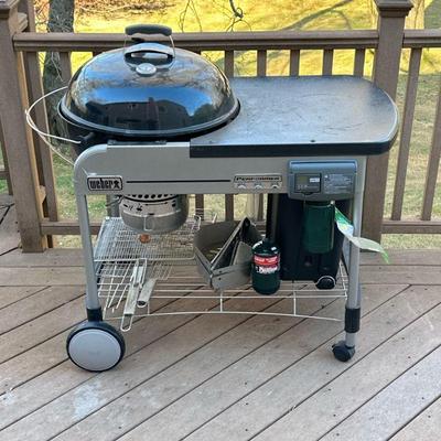 WEBER PERFORMER CHARCOAL GRILL | Round Weber charcoal grill with built-in propane ignition, metal top, and charcoal storage bin all...