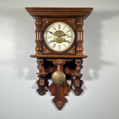 CARVED WOOD WALL CLOCK | The face with Roman numeral markers and central pressed brass medallion; with a matched carved leaf crest. - h....