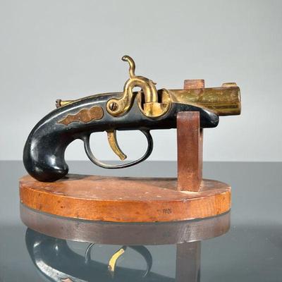 VINTAGE DERRINGER LIGHTER | Plugged derringer pistol-form lighter with brass barrel, on a wood stand. - l. 5.5 in (derringer)

