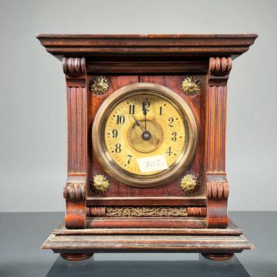 SMALL WOODEN SHELF CLOCK | Carved wood shelf clock with fluted sides, the face with Arabic numeral markers, with applied brass elements....