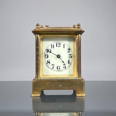 SMALL WATERBURY CARRIAGE CLOCK | A Waterbury Clock Co. Brass carriage clock with beveled glass panels, the face with Arabic numerals and...