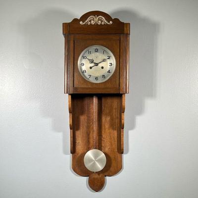 CARVED OAK WALL CLOCK | With a stepped carved case. - h. 34.5 x w. 12.5 x d. 6 in

