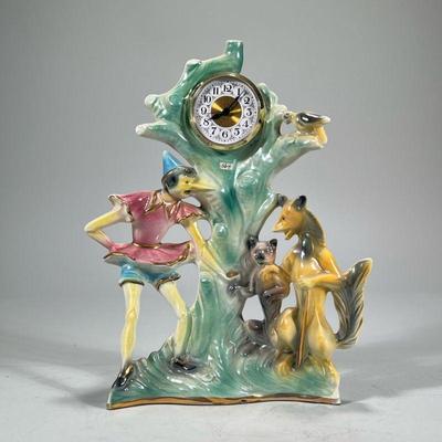 PORCELAIN FIGURAL CLOCK | Italian luster porcelain figural clock depicting Pinocchio and animals, the face with Arabic numerals. - h. 13...