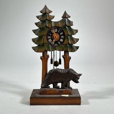 GERMAN WOOD-CARVED CLOCK | Grieshaber carved and painted with two trees and a bear, the face marked "Germany" and having Roman...