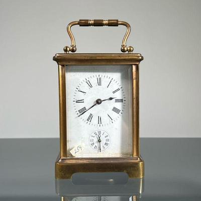 FRENCH CARRIAGE CLOCK | Brass case with beveled glass panels, including a top oval window, the face with Roman numerals and sub dial,...