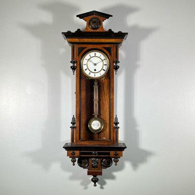 “RA” VIENNA REGULATOR WALL CLOCK | White enameled face with black Roman numeral markers and an enamel decorated pendulum signed...