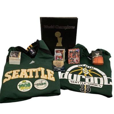 TN219 Seattle SuperSonic’s Memorabilia & More	1978-1979 World Champions Book. Couple of XL shirts and some basketball trading cards....