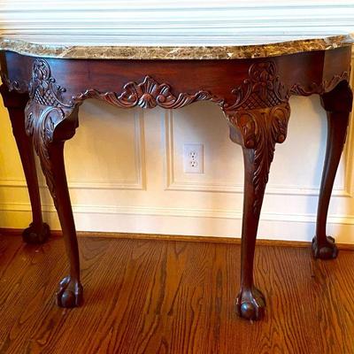 Marble top, demi-lune, carved table by Henkel Harris.