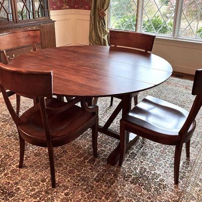 Round, wood, drop leaf table by Harden and four wood chairs (2 arm, 2 side) by Nichols & Stone.