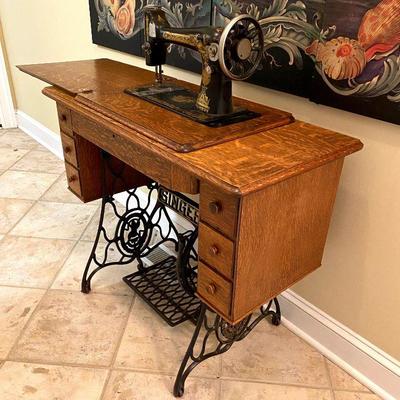 Antique Singer sewing machine built into oak work cabinet.