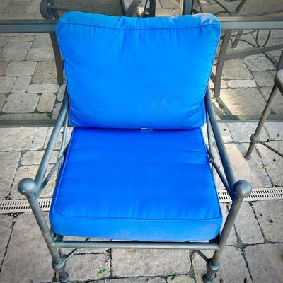 Four black metal outdoor chairs - two have solid blue upper cushions, and two have blue & white striped upper cushions. Three...