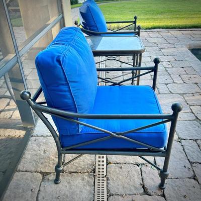 Four black metal outdoor chairs - two have solid blue upper cushions, and two have blue & white striped upper cushions. Three...