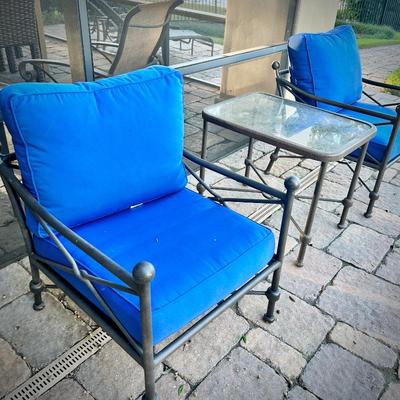 Four black metal outdoor chairs - two have solid blue upper cushions, and two have blue & white striped upper cushions. Three...