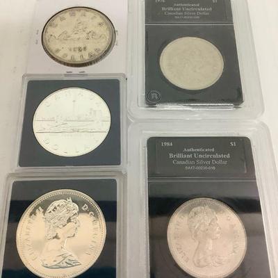 TN49 Group Of Canadian Dollars	Mix of sealed, graded, ungraded, circulated and uncirculated Canadian silver dollar coins. Five coins total.
