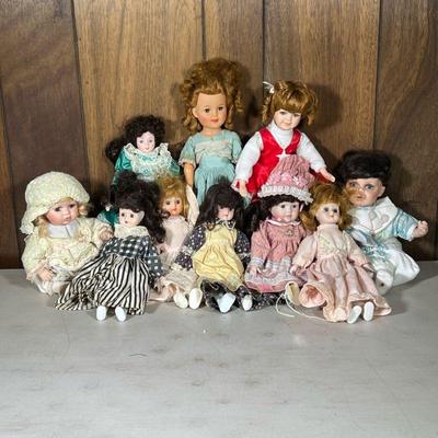 (10pc) Porcelain & Other Dolls | Including two porcelain baby dolls, two similar porcelain head dolls, a porcelain cheerleader doll,...