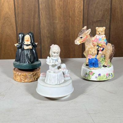 (3pc) Music Boxes | Including a porcelain tea party music box, a porcelain heritage mint music box with teddy bears, and a nun music box....