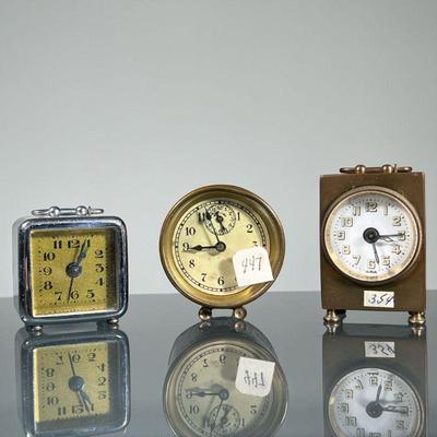 (3pc) MINIATURE ALARM CLOCKS | Including a French chrome cased clock, an American made barrel clock, and a German brass carriage clock,...