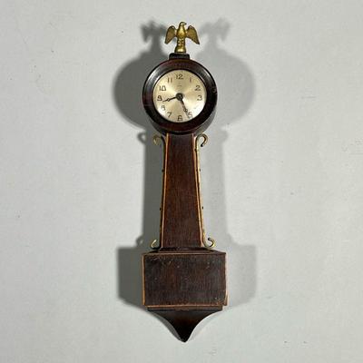MINIATURE NEW HAVEN BANJO | Miniature banjo clock by the New Haven Cock Company, 12 day, the silvered dial signed and with Arabic...