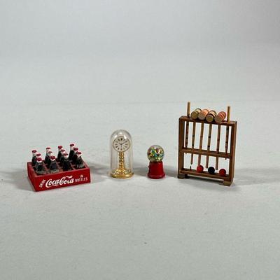 (4pc) DOLLHOUSE MINIATURES | Including a miniature croquet set, a case of coca-cola bottles, a domed brass clock, and a gumball machine....
